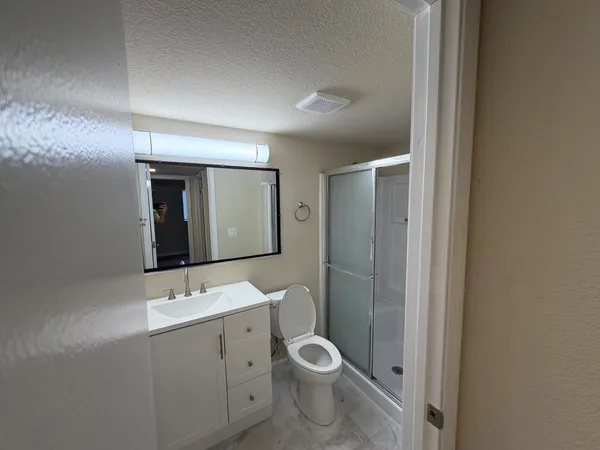 a bathroom with a toilet sink shower and mirror