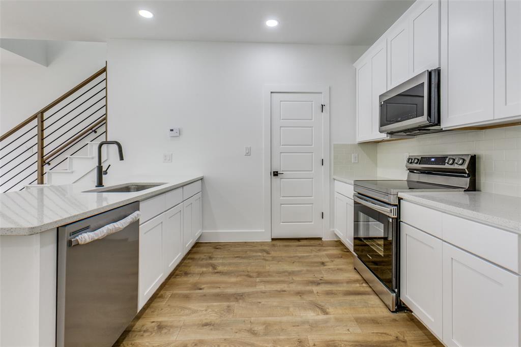 9475 Timberleaf Drive Dallas, TX 75243 - Photo 13 of 38 a kitchen with stainless steel appliances granite countertop a sink and a stove top oven with wooden floor