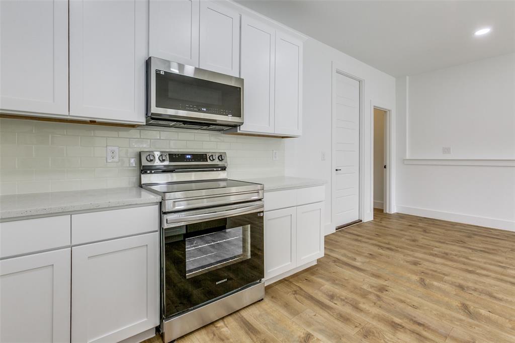 9475 Timberleaf Drive Dallas, TX 75243 - Photo 16 of 38 a kitchen with stainless steel appliances granite countertop a stove a microwave and a white cabinets