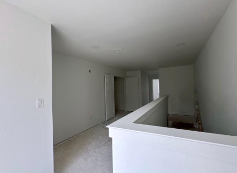 9475 Timberleaf Drive Dallas, TX 75243 - Photo 22 of 23 Corridor with unfinished concrete flooring and an upstairs landing