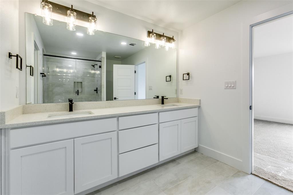 9475 Timberleaf Drive Dallas, TX 75243 - Photo 27 of 38 a bathroom with double sink and a mirror