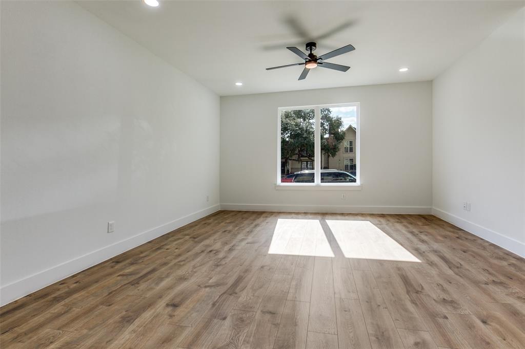 9475 Timberleaf Drive Dallas, TX 75243 - Photo 7 of 38 an empty room with wooden floor chandelier and windows