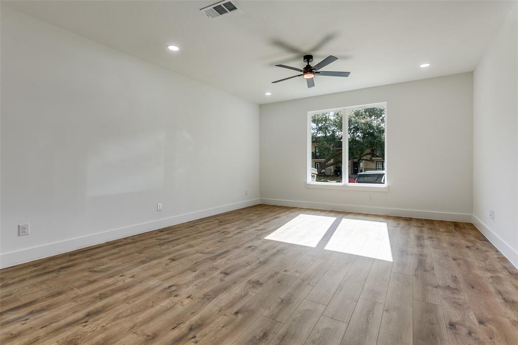 9475 Timberleaf Drive Dallas, TX 75243 - Photo 8 of 38 an empty room with wooden floor chandelier fan and windows