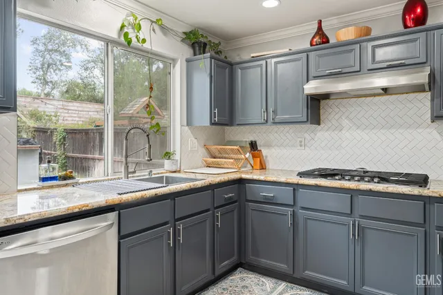 a kitchen with stainless steel appliances granite countertop a sink and a stove