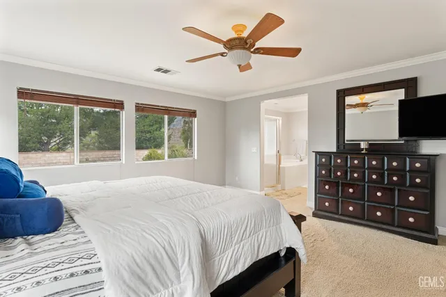 a bedroom with a large bed and a flat tv screen