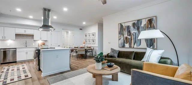 a living room with furniture and kitchen view