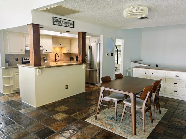 a kitchen with granite countertop a sink stove and cabinets