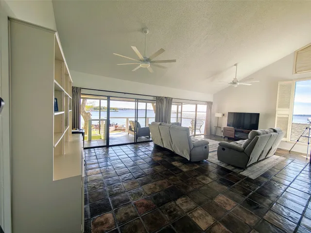 a kitchen with kitchen island a counter top space appliances and a view of living room