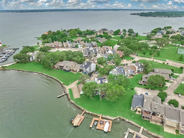 an aerial view of a house with a yard and lake view