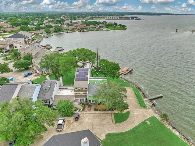 an aerial view of a house with a yard and lake view