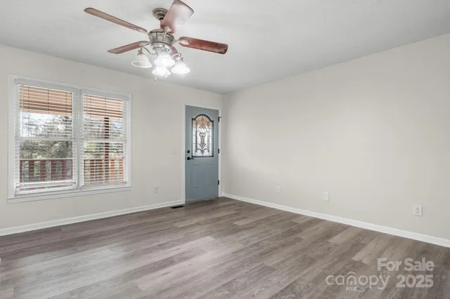 a view of a kitchen with wooden floor and windows