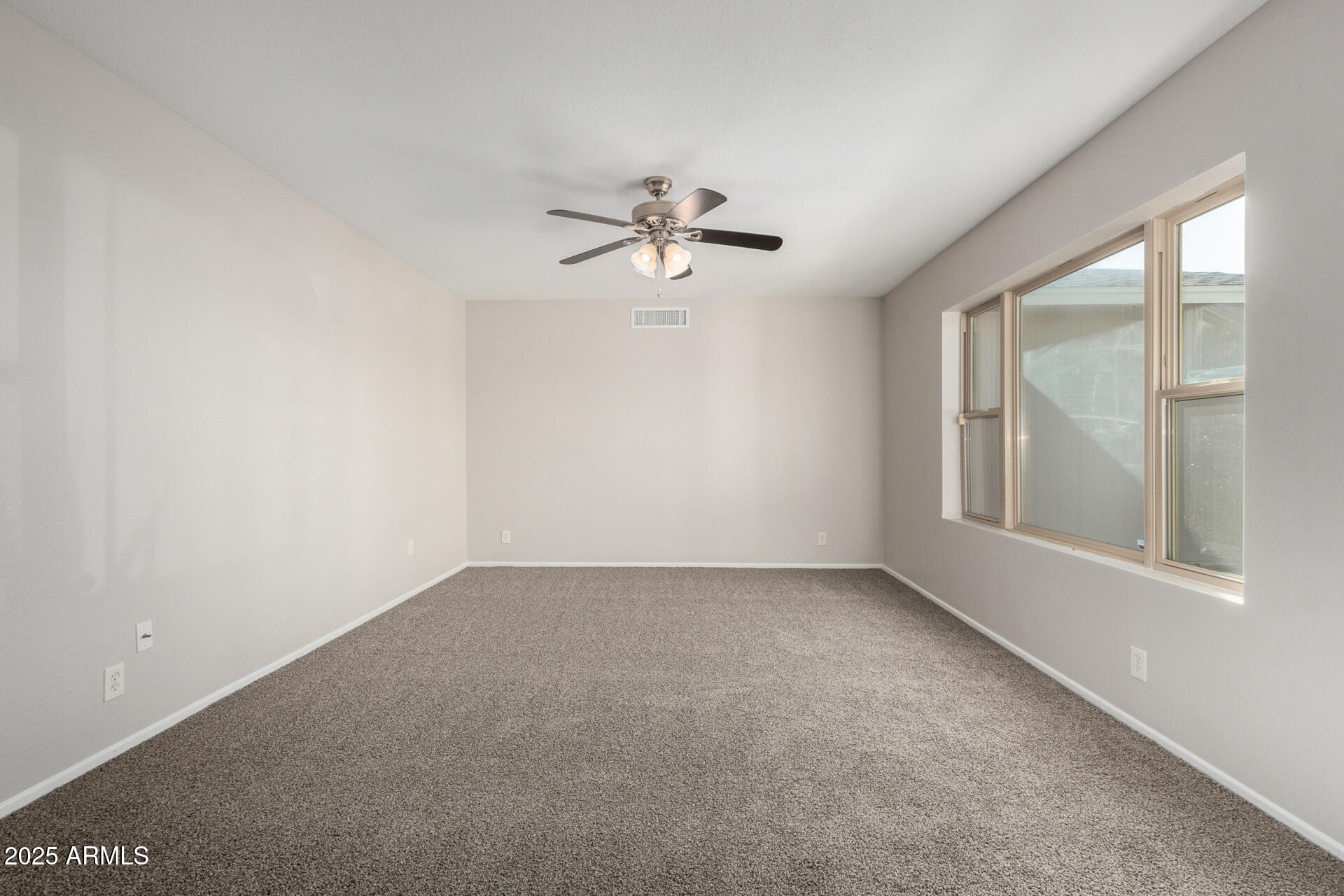 2201 South Evergreen Road Tempe, AZ 85282 - Photo 9 of 42 an empty room with windows and chandelier fan