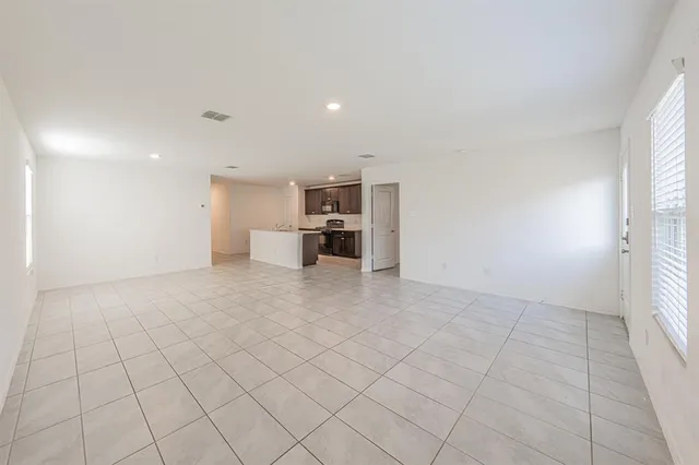 an empty room with fireplace and windows