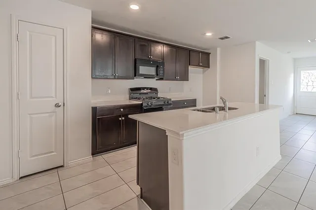 a kitchen with a sink a stove and cabinets