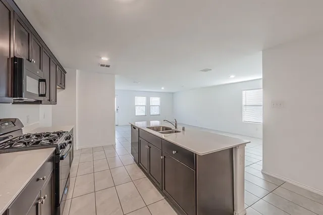 a kitchen with a sink stove and cabinets