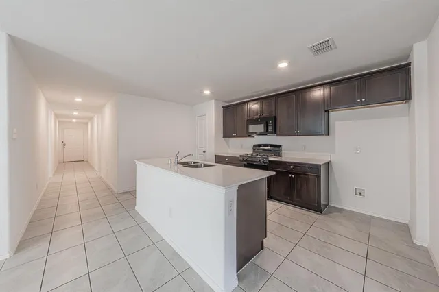 a kitchen with stainless steel appliances granite countertop a sink and a refrigerator