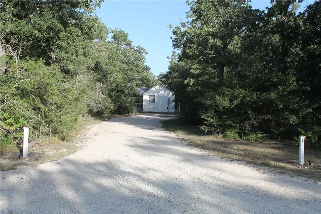 a pathway of a house with a yard
