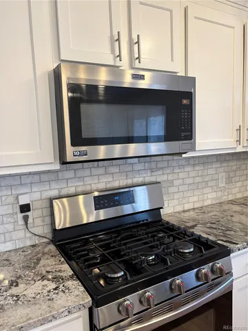 a stove top oven sitting inside of a kitchen