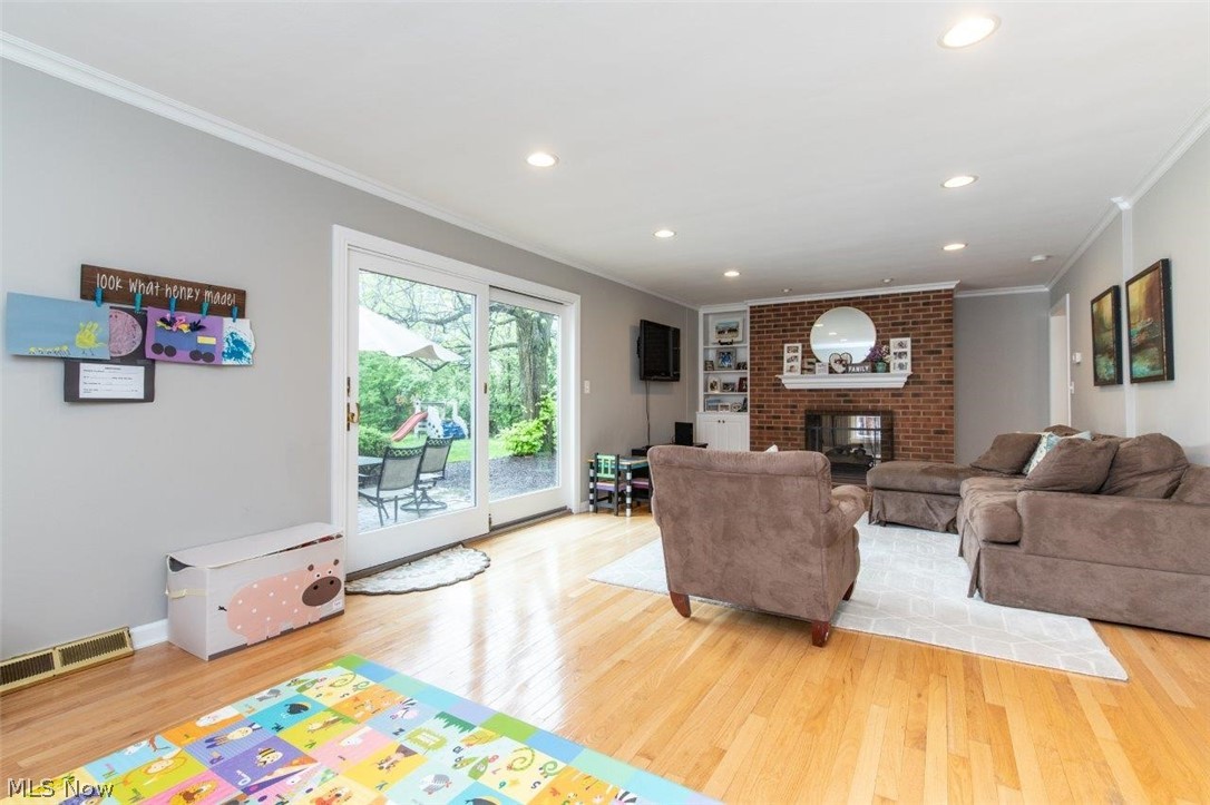 Large Family Room with 
Hardwood Floors, Two Sided Fireplace and Sliding Glass Doors Leading to the 
Brick paver Patio 
