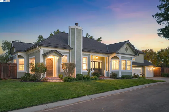 a front view of a house with a garden and plants