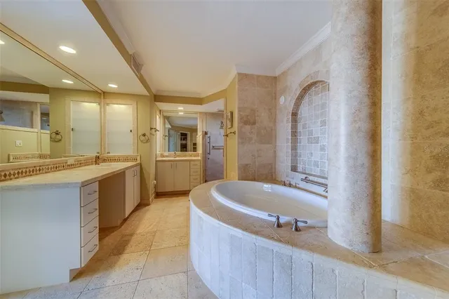 a spacious bathroom with a tub sink and mirror