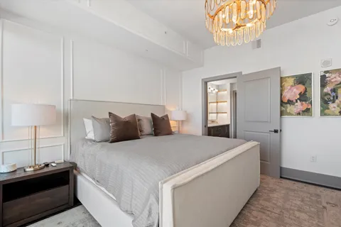 a bedroom with a large bed and a chandelier