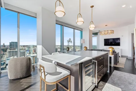 a kitchen with stainless steel appliances granite countertop a sink a stove and a wooden floors