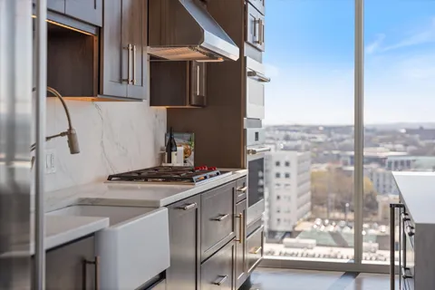 a view of a hallway with wooden floor and cabinets