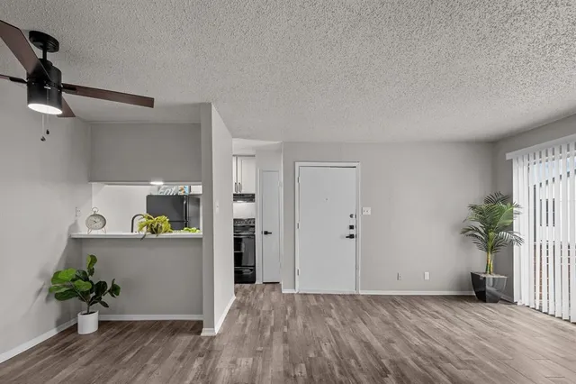a view of a kitchen with wooden floor and a potted plant