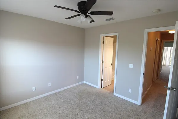 an empty room and chandelier fan