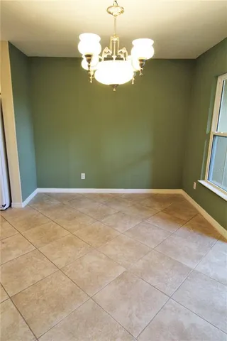 a view of a room with a chandelier fan and kitchen view