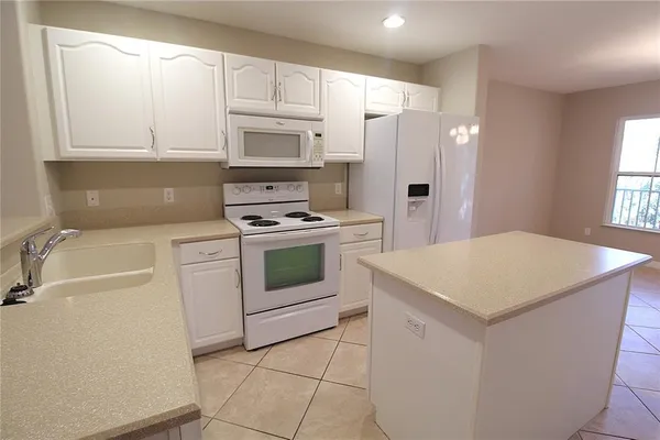 a kitchen with white cabinets and white appliances