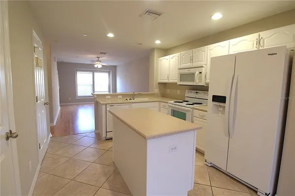 a kitchen with a sink a counter top space cabinets and stainless steel appliances