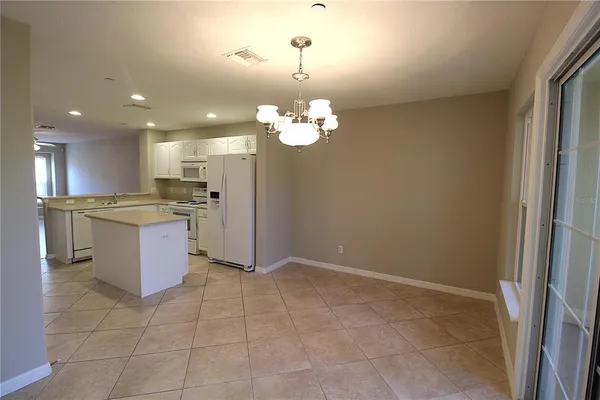 a kitchen with a refrigerator and a stove top oven