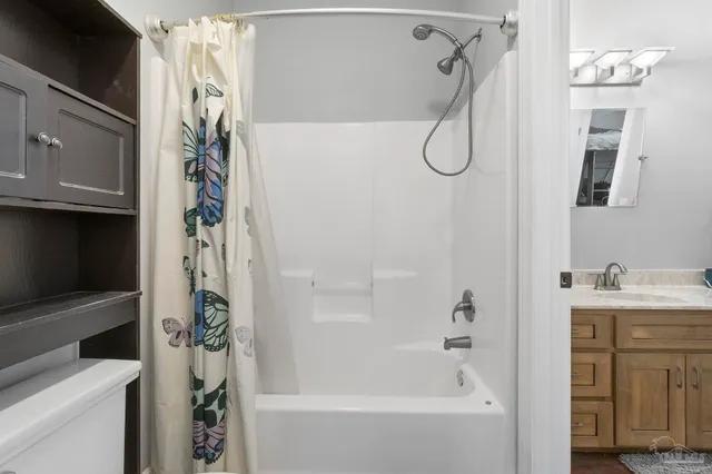 a bathroom with a double vanity sink a mirror a bathtub and shower