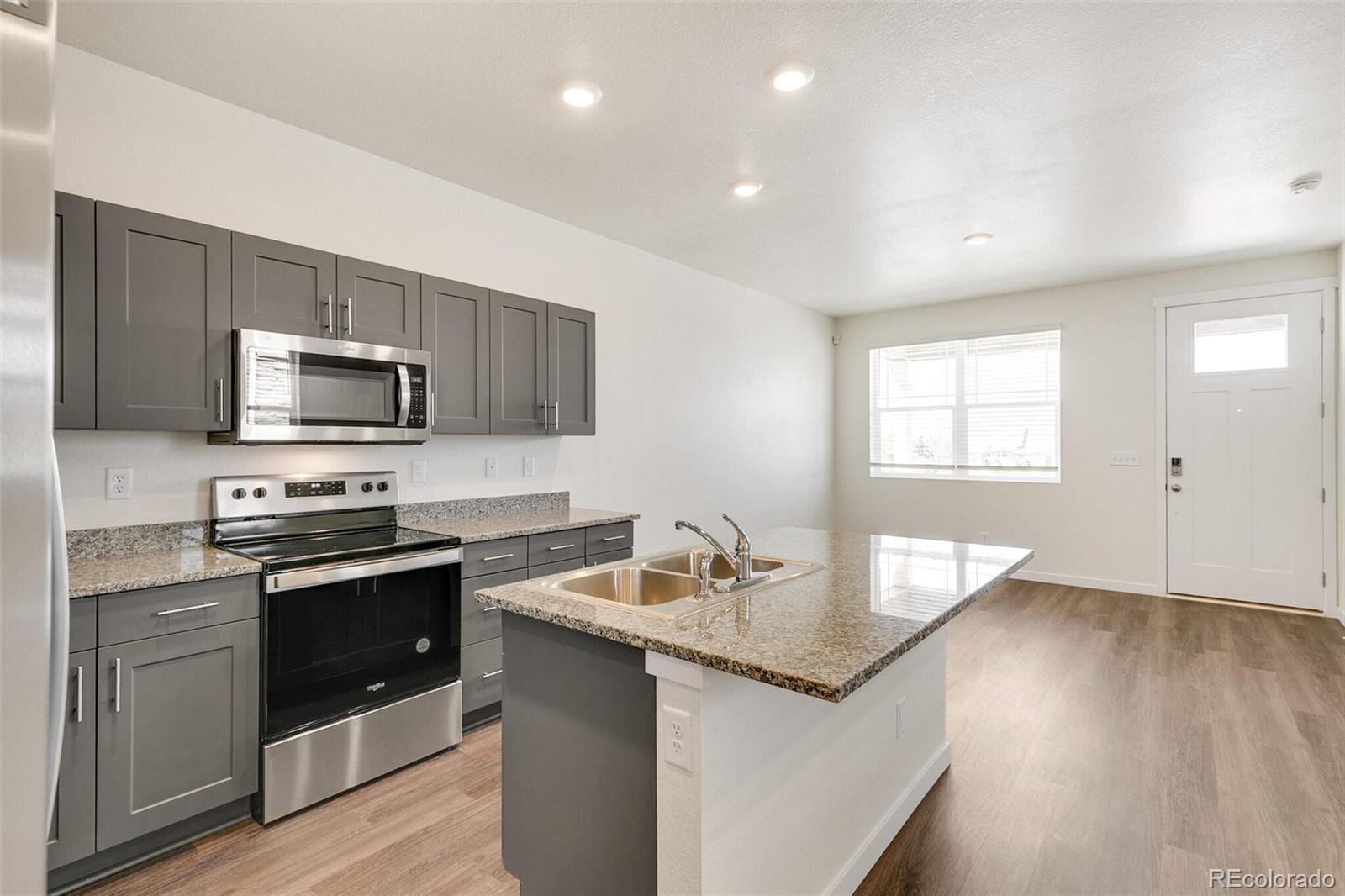 6907 Zig Place Frederick, CO 80530 - Photo 11 of 36 a kitchen with granite countertop a sink and steel appliances