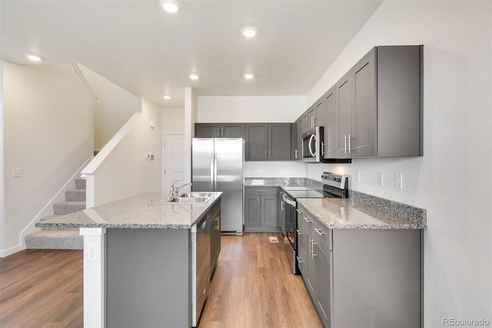 6907 Zig Place Frederick, CO 80530 - Photo 12 of 36 a kitchen with a sink a counter top space stainless steel appliances and cabinets