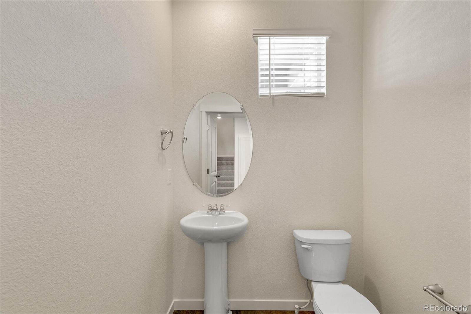 6907 Zig Place Frederick, CO 80530 - Photo 15 of 36 a bathroom with a toilet a sink and a window