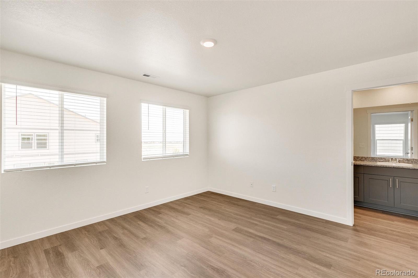 6907 Zig Place Frederick, CO 80530 - Photo 18 of 36 an empty room with wooden floor and windows