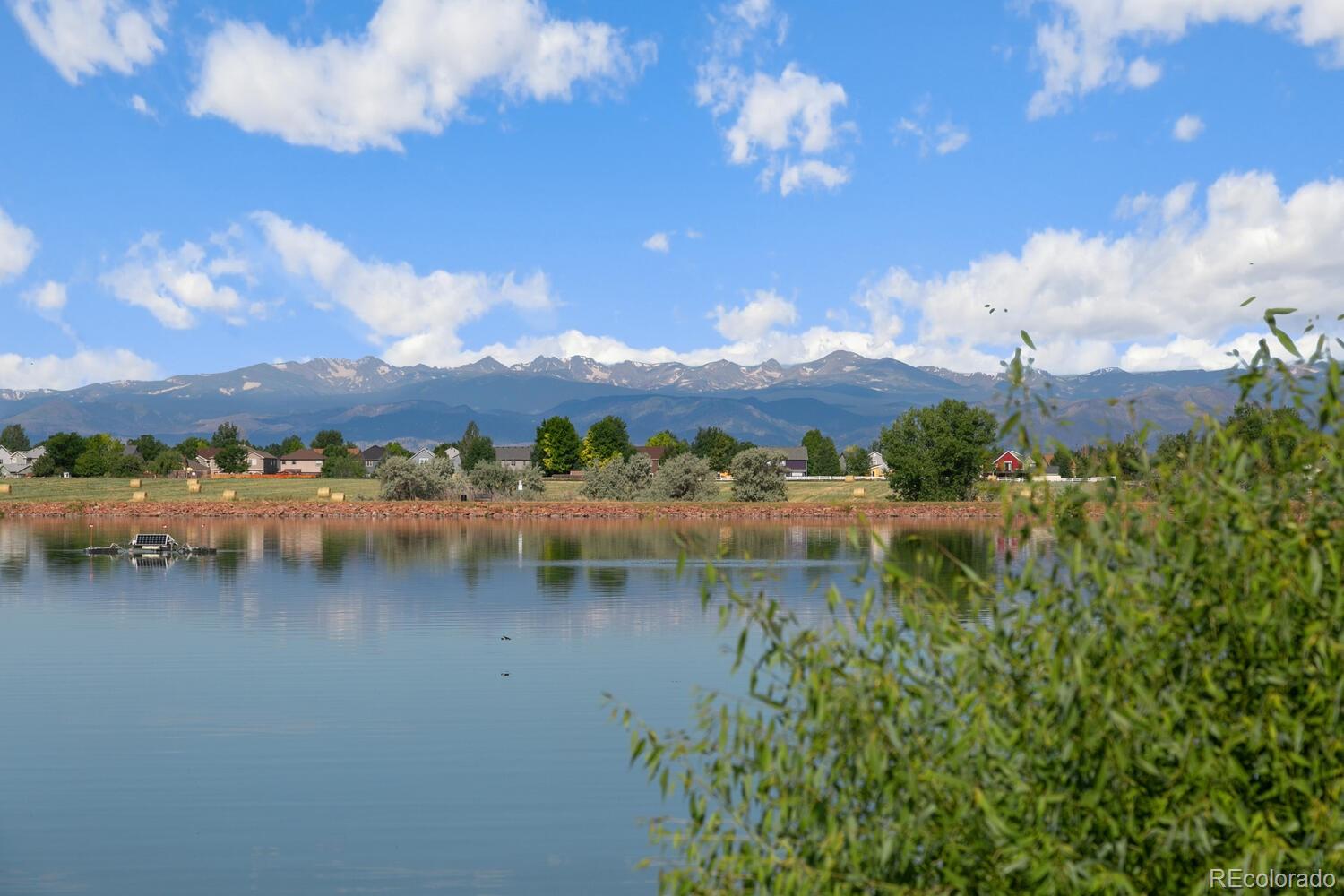6907 Zig Place Frederick, CO 80530 - Photo 30 of 36 a view of a lake with houses in the back