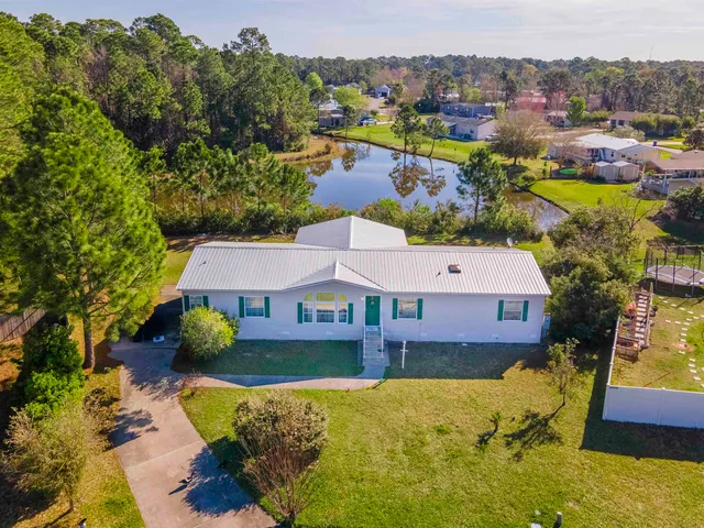 an aerial view of a house with a swimming pool outdoor seating and yard
