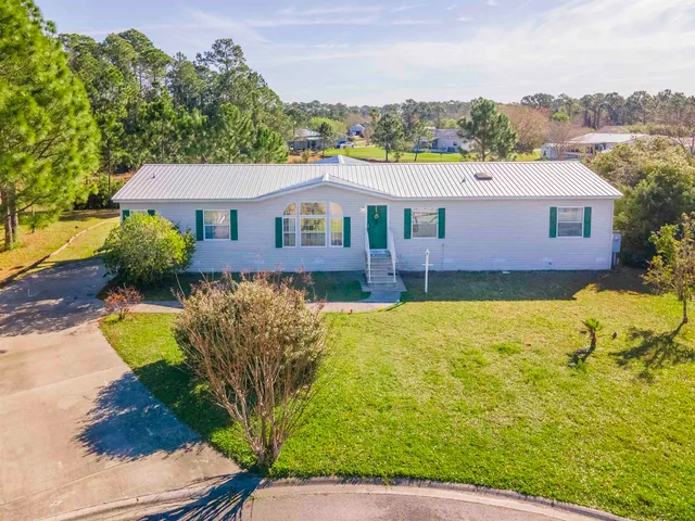 a view of a house with pool plants and large trees