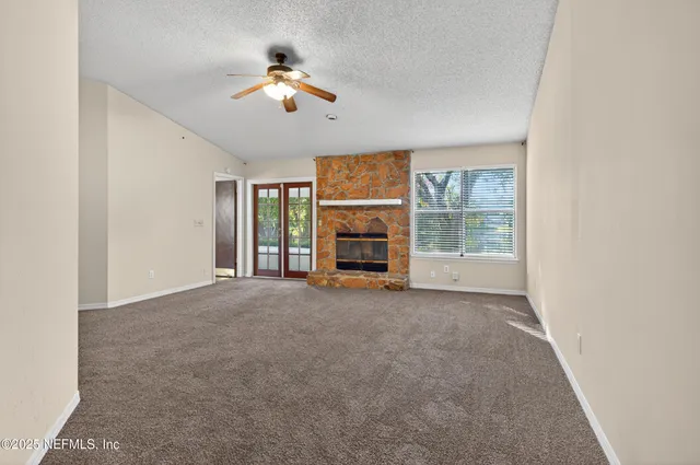 an empty room with fireplace and window
