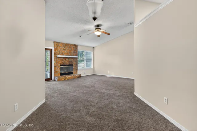 an empty room with a ceiling fan and a window