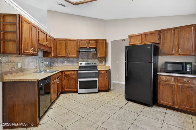 a kitchen with stainless steel appliances granite countertop a refrigerator stove a sink and dishwasher