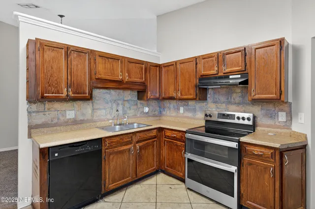 a kitchen with stainless steel appliances granite countertop a sink stove and microwave