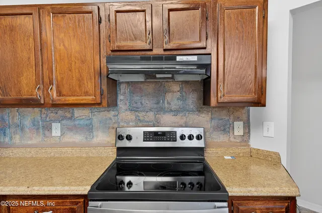 a stove top oven sitting inside of a kitchen