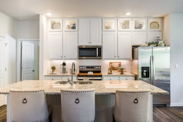 a kitchen with granite countertop a sink a stove and cabinets