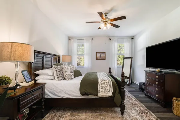 a bedroom with a bed and a flat tv screen on dresser