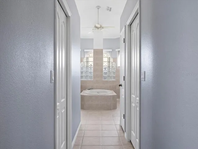 a spacious bathroom with a tub sink and mirror